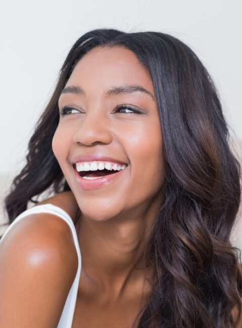 woman with amazing curly hair smiling and looking into the distance