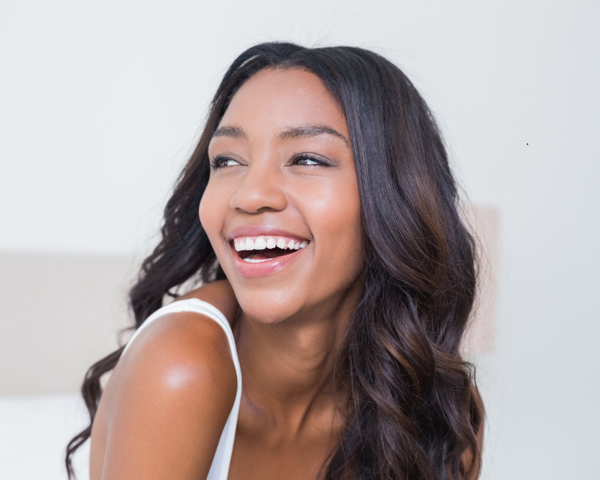 woman with amazing curly hair smiling and looking into the distance
