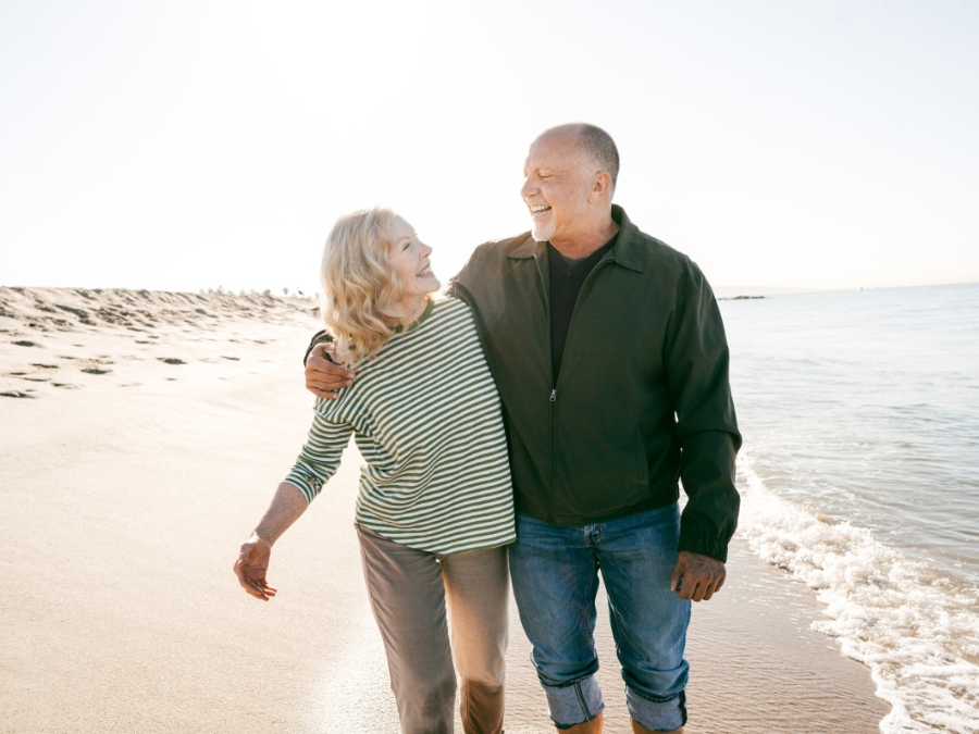 couple in their 50s walking on a beach