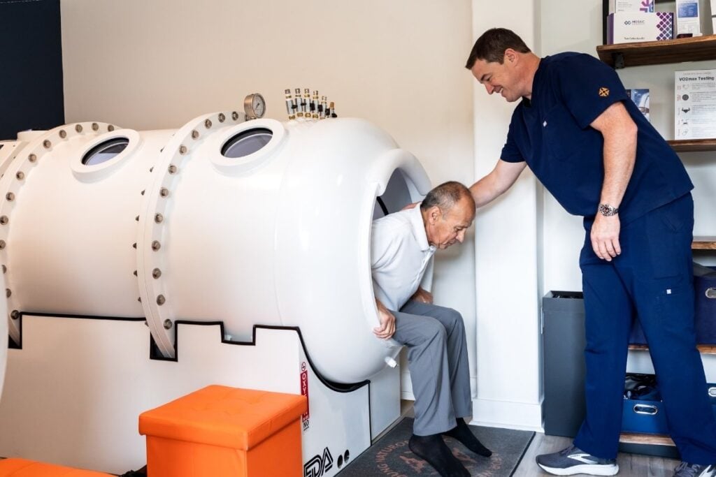Hyperbaric Oxygen Therapy - man being attended at a hyperbaric chamber by male healthcare tanks